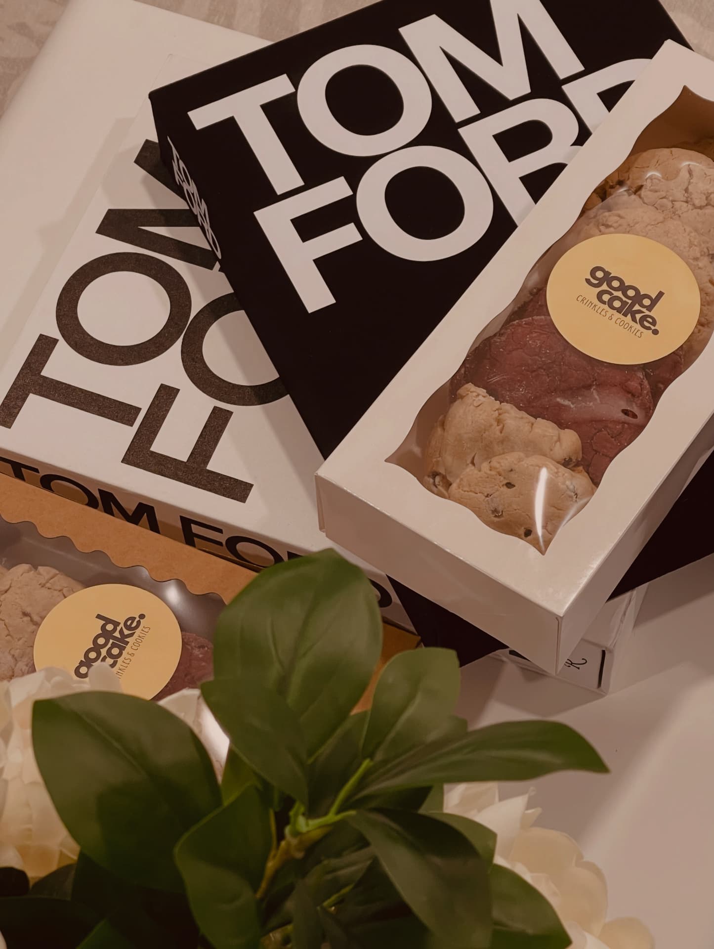 White GoodCake cookie box on Tom Ford books with foliage